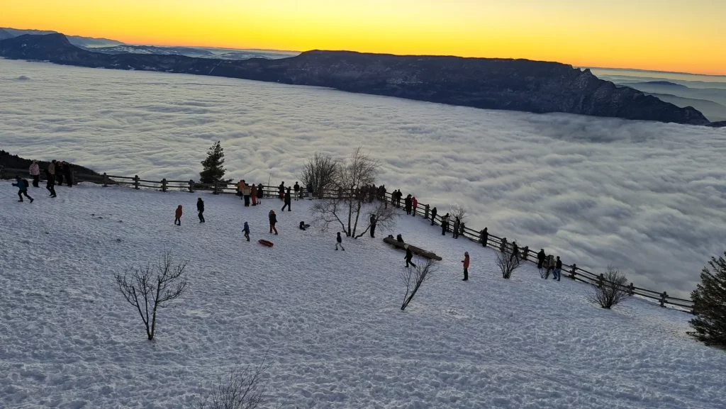 Promeneurs au belvédère du Revard au-dessus d'une mer de nuages